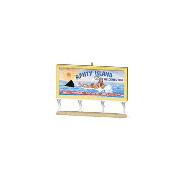 Model of a 'Jaws' Amity Island billboard with shark and beach scene on a white background. Celebrate 50 years of Jaws with this unique Christmas ornament! Featuring the iconic Amity Island billboard, it’s a must-have for fans. Get yours today!